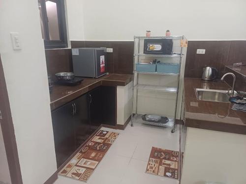 利帕Affordable 2 BR Transient House in Lipa City Batangas的一间带水槽和微波炉的小厨房