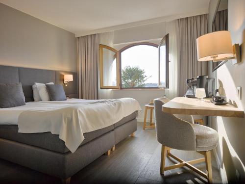 富伦科梅尔酒店的酒店客房,配有床、桌子和椅子