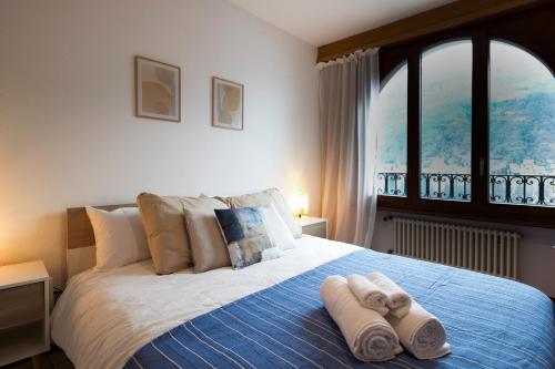 门德里西奥4.5 locali magnifica vista lago e parking pubblico的一间卧室配有带毛巾的床