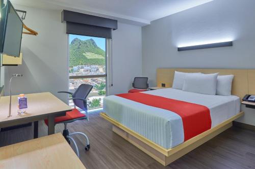 蒙特雷蒙特雷林达维斯塔城市快捷酒店的配有一张床、一张书桌和一扇窗户的酒店客房