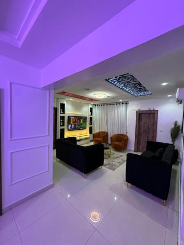 拉各斯SAMBEST Home的客厅设有紫色天花板和沙发。