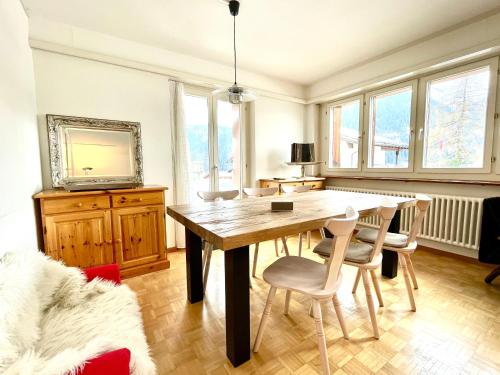 塞德龙Swiss Alpine Hideaway的一间带木桌和椅子的用餐室