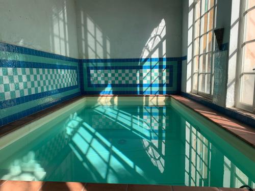 卢卡卡萨莱迪罗西住宿加早餐旅馆的游泳池拥有蓝色和白色的墙壁和窗户