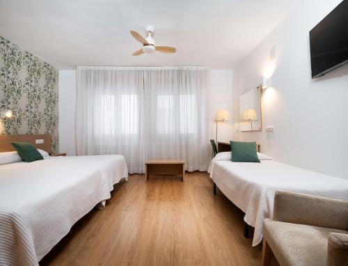 沙比纳尼哥我家酒店的酒店客房配有两张床和吊扇。