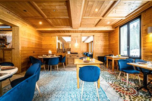 夏蒙尼-勃朗峰L'Arveyron Open House的餐厅拥有木墙和蓝色的桌椅