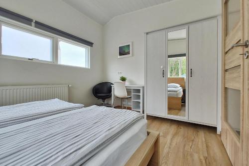 塞济斯菲厄泽Túngata apartment的一间卧室配有一张床、一张书桌和一面镜子