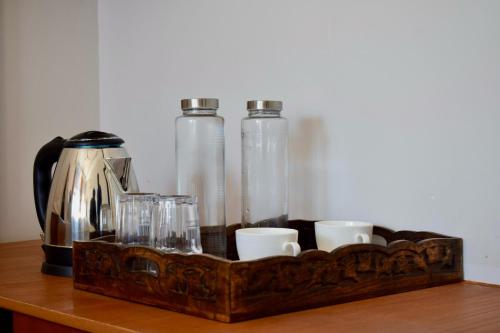 UkhimathHumming Bird By Aaryam的一张桌子上装有杯子和瓶子的木托盘