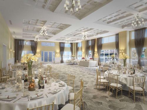 杜威海滩杜威海滩凯悦广场酒店的宴会厅配有白色的桌椅和吊灯