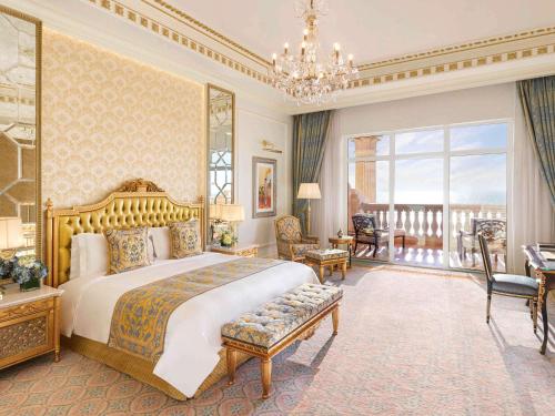 迪拜Raffles The Palm的一间带大床的卧室和一个阳台