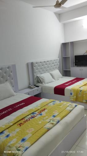 达卡Hotel living international ltd.的卧室内两张并排的床