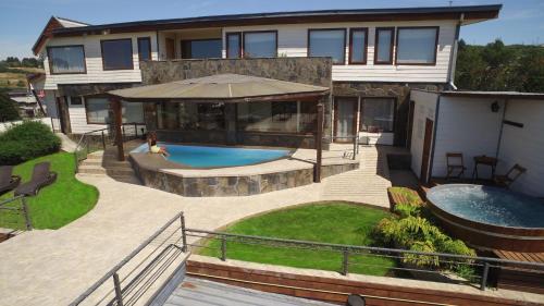 巴拉斯港Dein Haus Hotel y Departamentos的后院带游泳池的房子