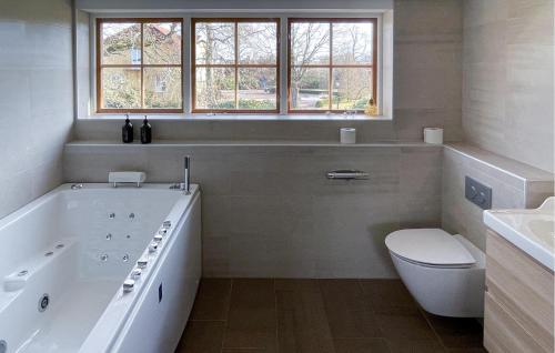 延雪平4 Bedroom Cozy Home In Jnkping的白色的浴室设有浴缸和卫生间。