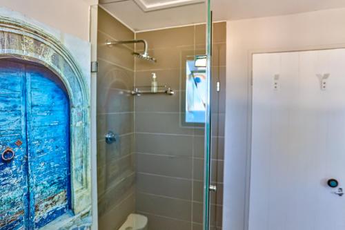 巴利托10 AKROTIRI, SANTORINI ESTATE - Families only的带淋浴的浴室和蓝色门