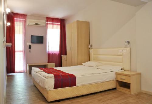希典Rilena Hotel的一间卧室配有一张带红色窗帘的大床