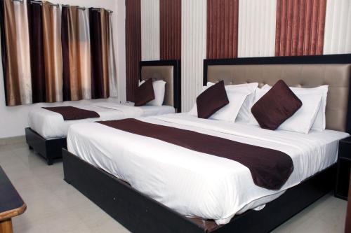哈里瓦Hotel Anand的酒店客房的两张床