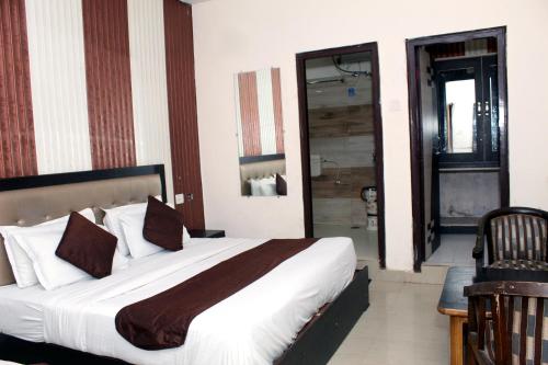哈里瓦Hotel Anand的一间带大床的卧室和一间浴室