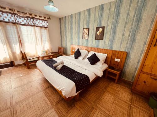 马拉里Mountain View Resort - A Hidden Resort Manali的卧室配有一张带白色床单和枕头的大床。