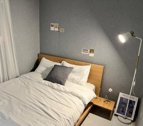 首尔Masil的一间卧室配有一张床和一张带台灯的桌子
