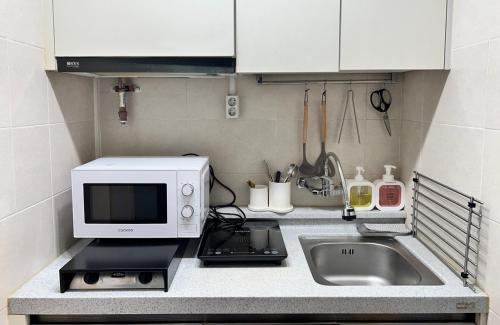 首尔Masil的厨房柜台配有微波炉和水槽