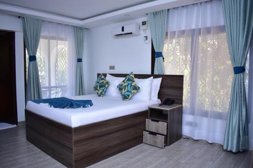 蒙巴萨Makaazi Nyali的一间卧室配有一张带蓝色窗帘的大床