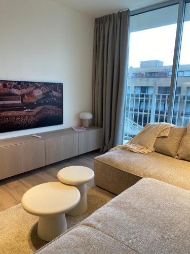 尼乌波特Luxe appartement `t Sant Nieuwpoort Bad的带沙发和大窗户的客厅