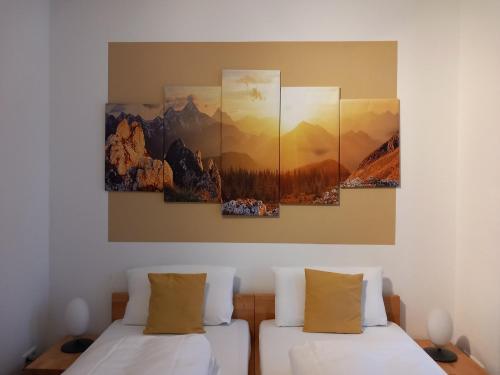杜塞尔多夫卡洛林格酒店的墙上有三幅画作的房间,设有两张床
