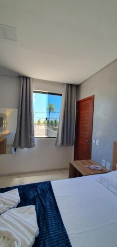 阿拉卡茹Hotel Da Orla的酒店客房设有两张床和窗户。