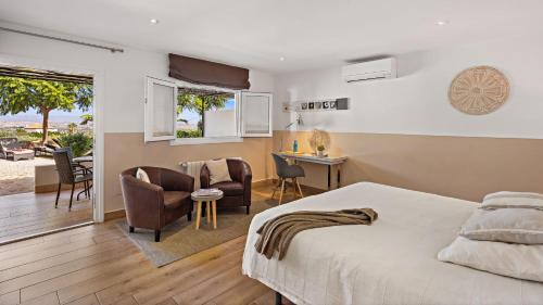莫哈卡尔Boutique Hotel Cortijo El Sarmiento的卧室配有一张床、一张桌子和椅子