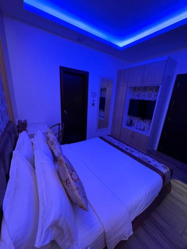 马累Summer Beach Maldives的卧室配有白色床和蓝色天花板