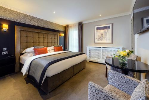 基拉尼基拉尼橡树酒店的一间卧室配有一张大床和一张桌子