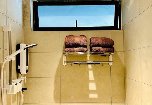 SematanBeachfront Retreats @RoxyBeachSematanApt.的一间带毛巾架和窗户的浴室