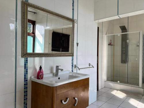 MatolaTR GUEST HOUSE的一间带水槽、镜子和淋浴的浴室