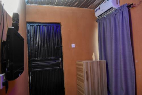 IkoroduMore Point Lounge的一间设有黑色门和紫色窗帘的房间