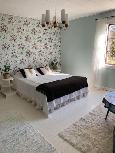 Lantligt boende nära Kastelholms golf och Smakbyn的卧室配有一张床铺,位于带花卉壁纸的房间