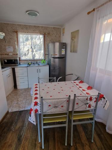 巴伊亚英格莱萨Cabañas Aquila D'Arroscia的一间带桌子的厨房和一间带冰箱的厨房