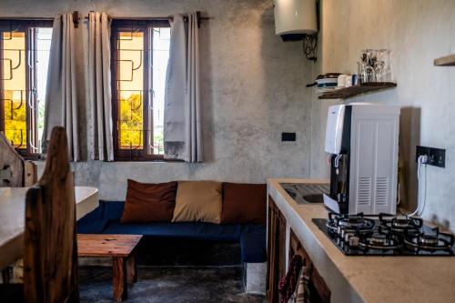 江比阿Baobab Bungalows的客厅设有蓝色沙发,厨房设有