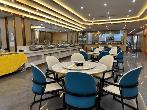 西哈努克XI AN JIU DIAN Hotel的餐厅设有蓝色和白色的椅子和桌子