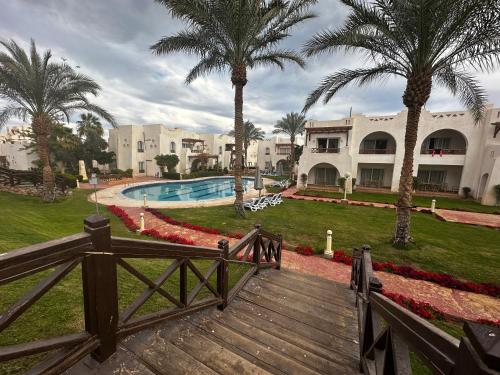 沙姆沙伊赫Private Luxury Villas at Sharm Dreams Resort的通往棕榈树度假村的木制走道