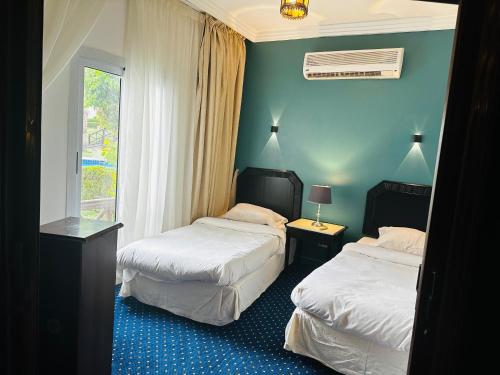 沙姆沙伊赫Private Luxury Villas at Sharm Dreams Resort的酒店客房设有两张床和窗户。