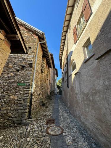 AstanoIl borgo di Astano的一条有建筑和鹅卵石街道的小巷