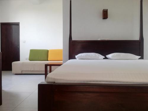 希克杜沃VILLA MAANE by GOODWILL的一间卧室配有一张床和一张沙发