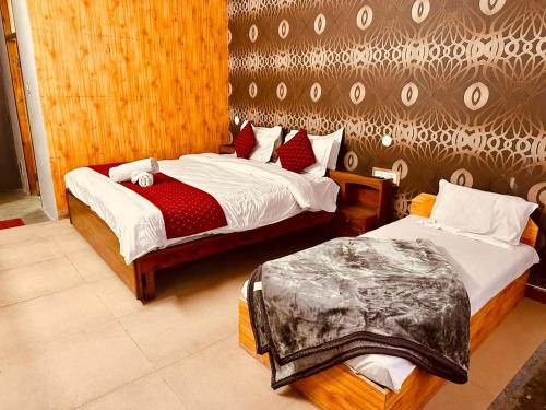 马拉里The Kanchan Hotel & Restaurant Manali的一间卧室,配有两张床