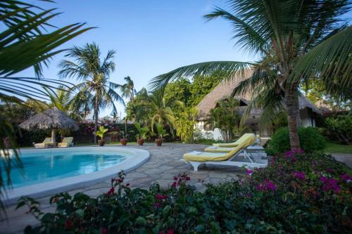 马林迪Villa Marine Park - Malindi的一个带2把躺椅的游泳池,棕榈树