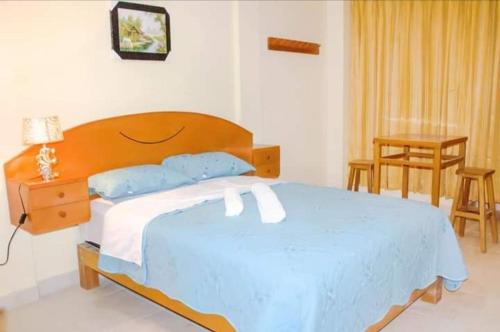 OlmosDominius Hotel的一间卧室配有一张大床和木制床头板