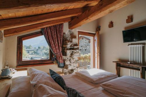 阿纳德Au coeur du village Chambes d'hôtes & SPA的一间卧室设有一张床和一个窗口