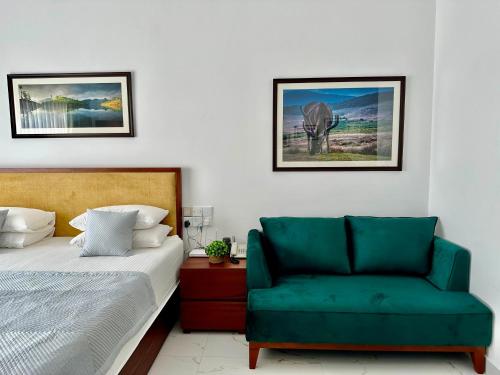 尼甘布Ocean Breeze Hotel Residencies BritLanka Apartments Negombo的一间卧室配有一张床和一把绿色椅子