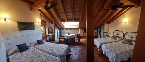 艾利翁阿达尔维乡村酒店的一间设有三张床的房间,内设一张桌子