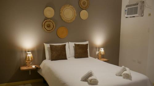 曼塔Park View Hostel & Suites的一间卧室配有一张带两盏灯的大型白色床。
