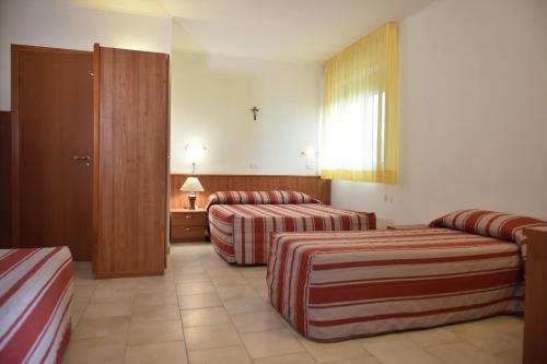 圣乔瓦尼·罗通多Hotel e Appartamenti La Solaria的酒店客房设有两张床和窗户。