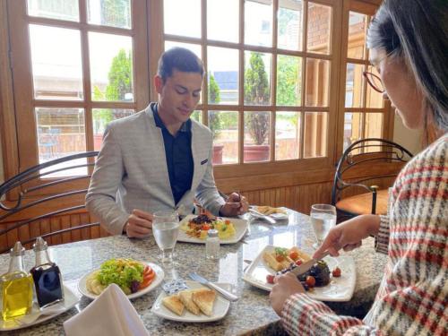 波哥大波哥大雷根锡乌萨昆酒店的坐在餐桌旁吃食物的男人和女人